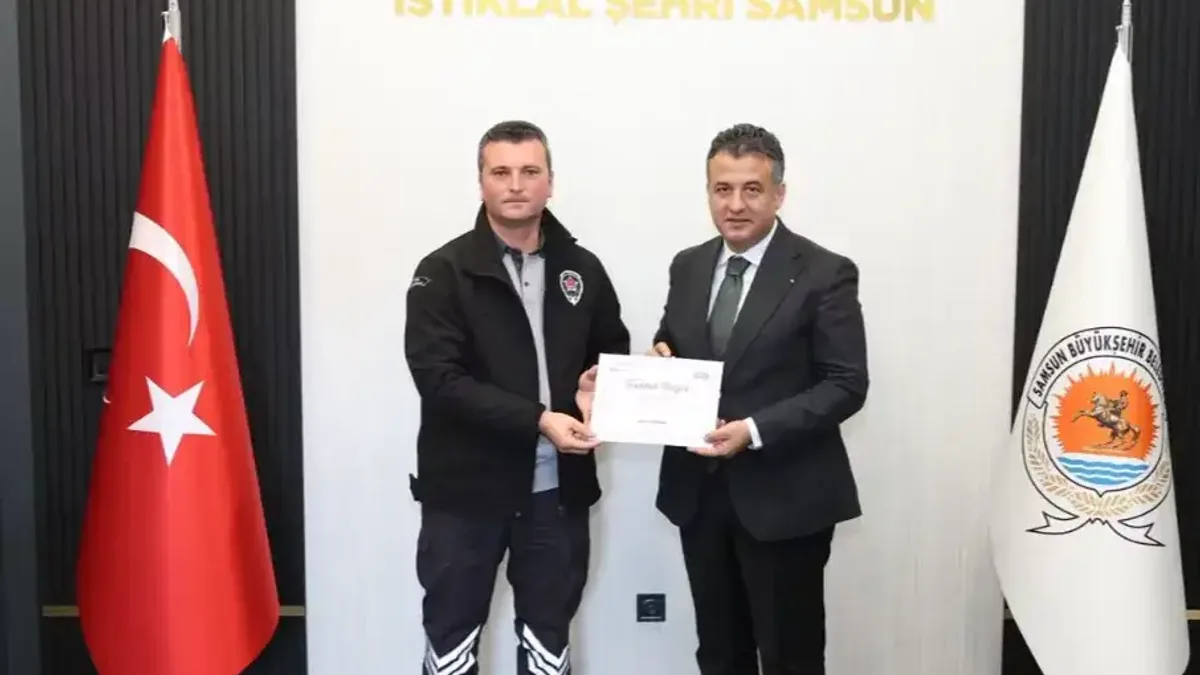 Samsun Büyükşehir Belediye Başkanı Halit Doğan, güvenlik görevlisi Muhammet Lafcı'ya teşekkür belgesi takdim ederken.