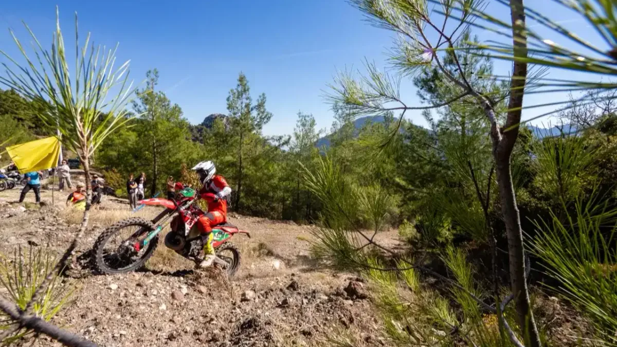 Antalya Kemer'deki ormanlık etapta tozlu parkurda ilerleyen enduro motosiklet yarışçıları.